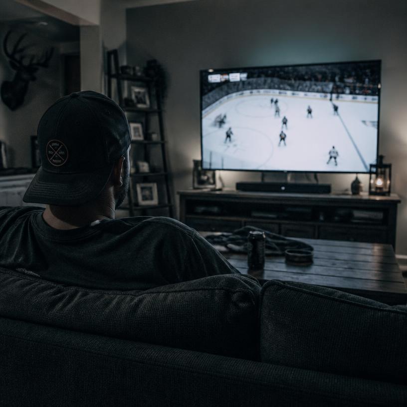 Homme regardant un match de hockey à la télévision à la maison